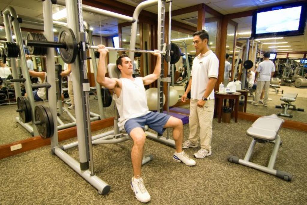 Marco Polo Davao Hotel Exterior photo A personal trainer assisting a client with a weight training exercise